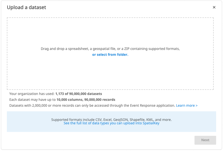 Image of a SpatialKey modal titled ‘Upload a dataset.’ The dialog prompts users to drag and drop a spreadsheet, geospatial file or ZIP file or select a file from a folder. Below the upload area, text shows dataset usage limits, including the number of datasets used and maximum columns and records allowed. A link provides more information about supported data types, and a disabled ‘Next’ button appears in the lower-right corner.