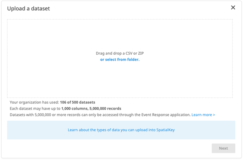Image of a SpatialKey modal titled ‘Upload a dataset.’ The dialog prompts users to drag and drop a CSV or ZIP file or select a file from a folder. Below the upload area, text shows dataset usage limits, including the number of datasets used and maximum columns and records allowed. A link provides more information about supported data types, and a disabled ‘Next’ button appears in the lower-right corner.